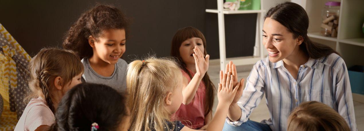 Quereinsteiger Kindergarten im sozialen Austausch mit Kindern bei Gruppenaktivitaet