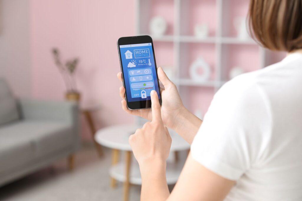Frau steuert per Smartphone ein Smart-Home-System – moderne Ergänzung zur Alltagshilfe wie Treppe Lift